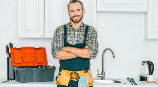 Plumber posing next to sink
